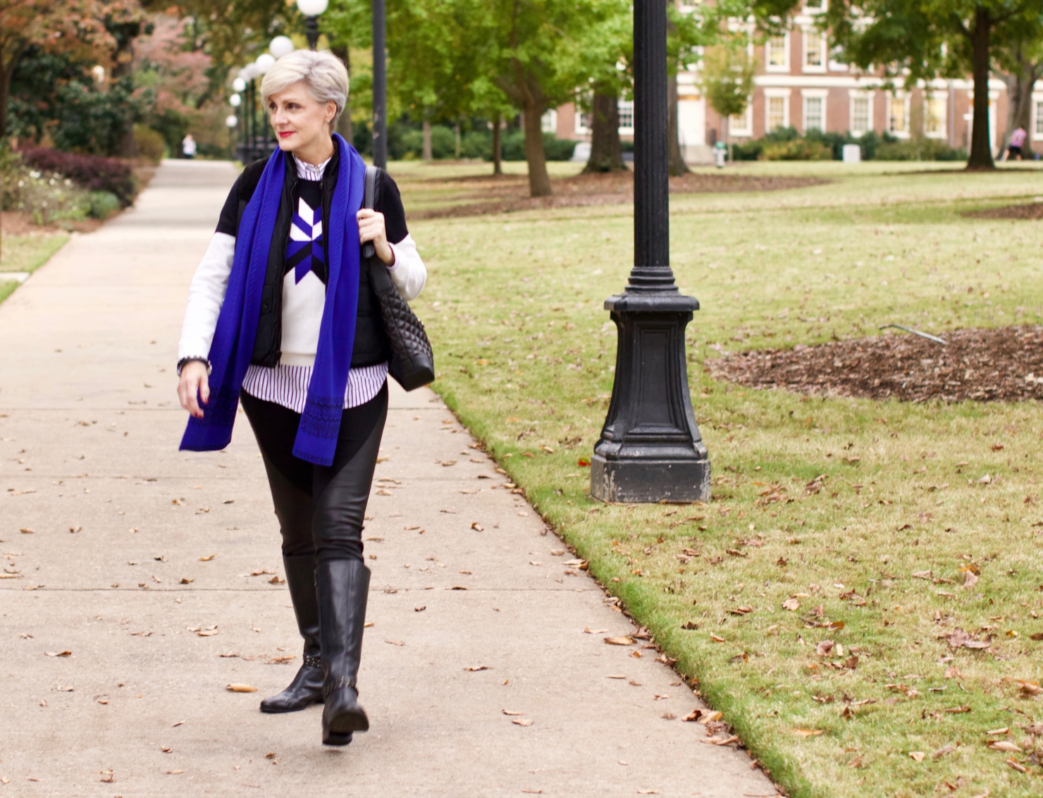 beth from Style at a Certain Age wears a snowflake intarsia sweater, DKNY ponte leggings, striped shirt, riding boots, and a cobalt blue intarsia trim scarf