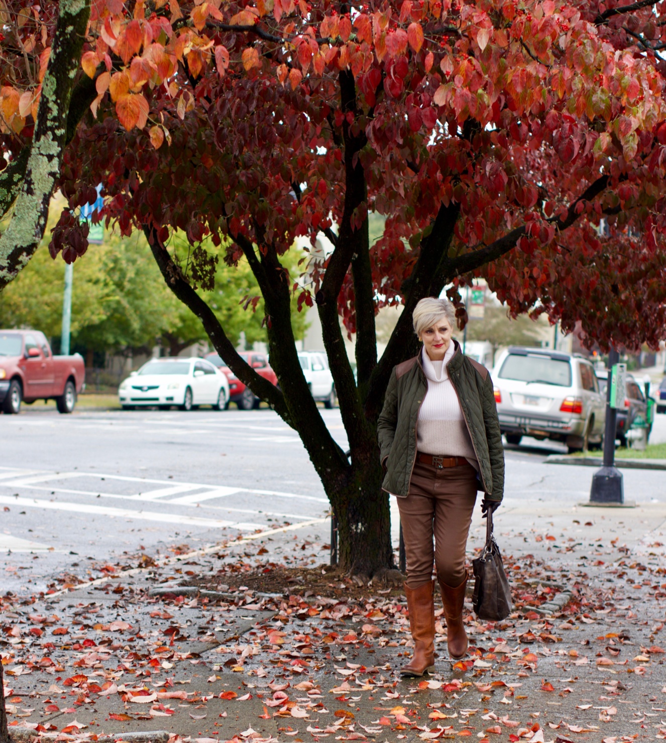 beth from Style at a Certain Age is wearing Ralph Lauren faux leather pants, chunky cashmere sweater, green utility jacket, Frye boots, and Frye hobo handbag