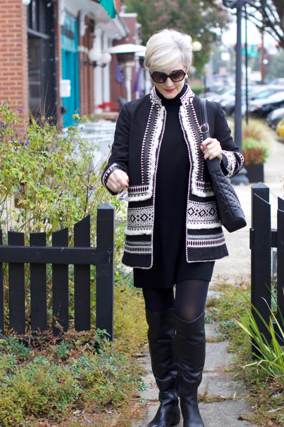 beth from style at a certain age wears a cashmere sweater dress from everlane, anthropologie embroidered jacket, black over the knee boots