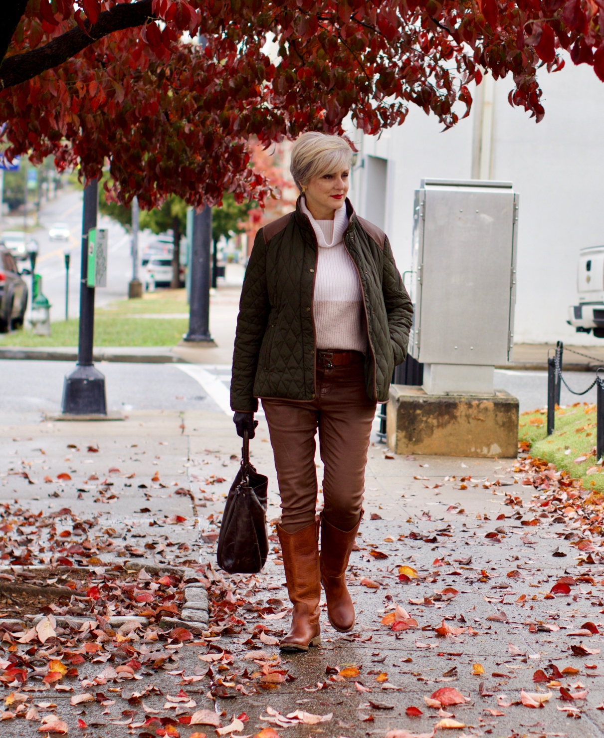 beth from Style at a Certain Age is wearing Ralph Lauren faux leather pants, chunky cashmere sweater, green utility jacket, Frye boots, and Frye hobo handbag