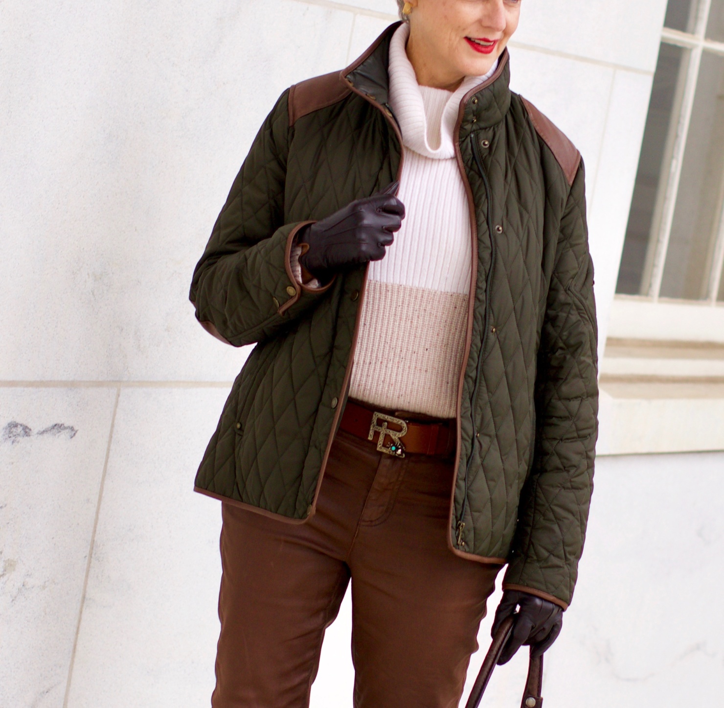 beth from Style at a Certain Age is wearing Ralph Lauren faux leather pants, chunky cashmere sweater, green utility jacket, Frye boots, and Frye hobo handbag