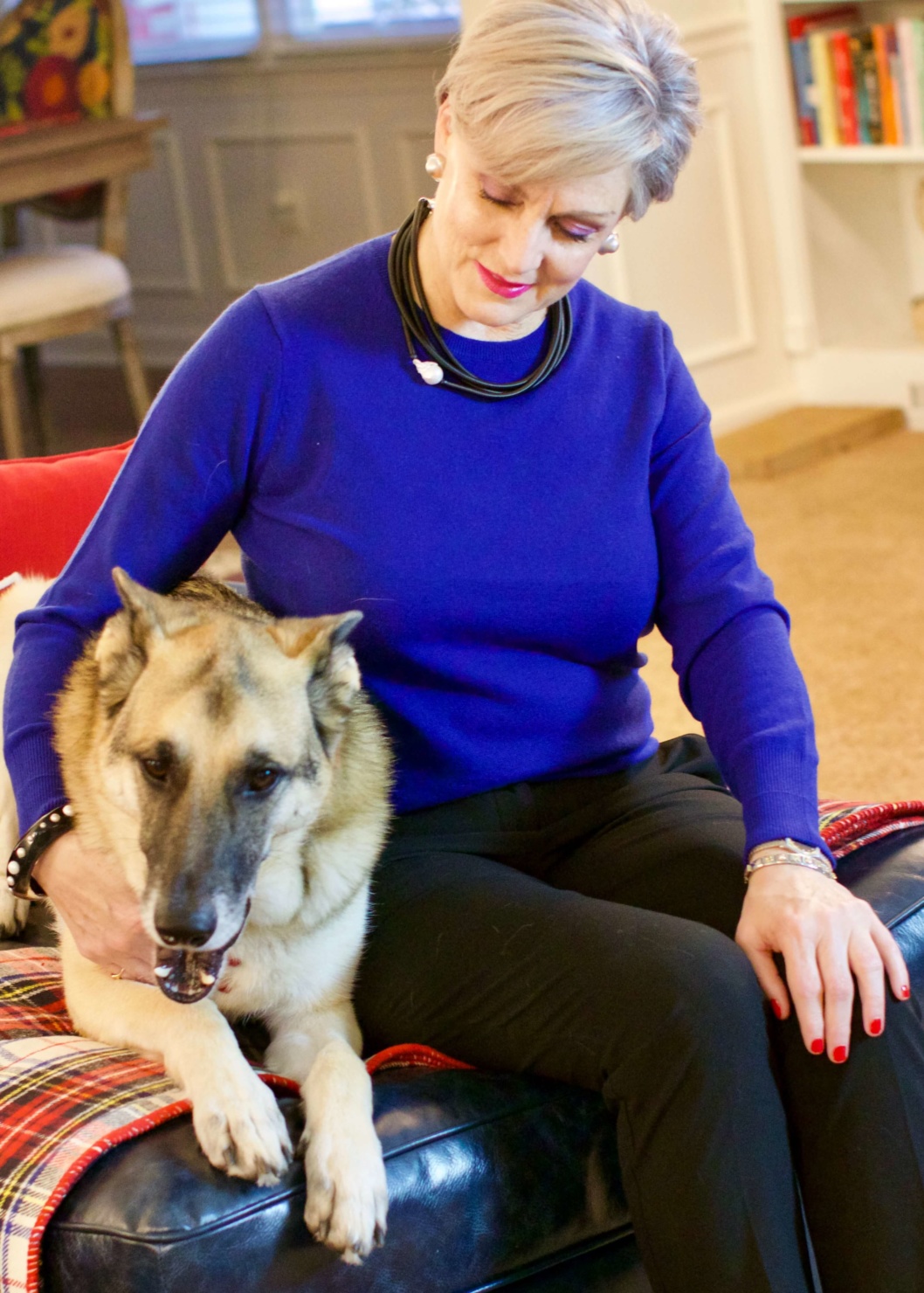 beth from Style at a Certain Age wears a cobalt blue cashmere crewneck, cropped black ankle pants, and tartan plaid flats