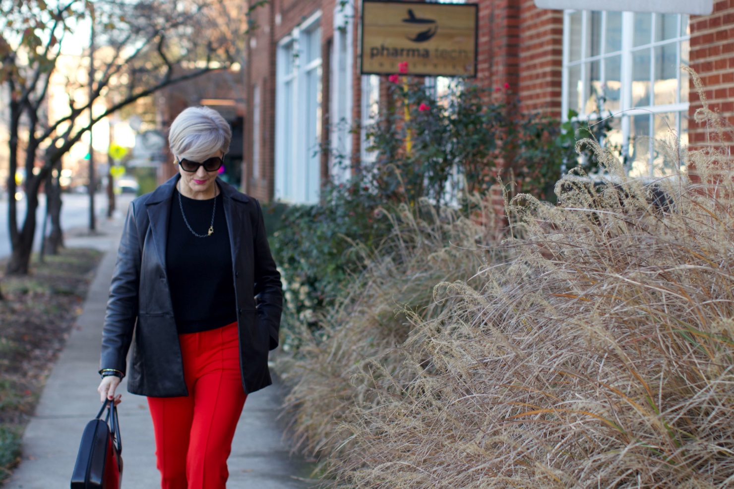 beth from Style at a Certain Age wears Anthropologie red pants, Everlane black cashmere crewneck, black leather blazer, and leopard pumps