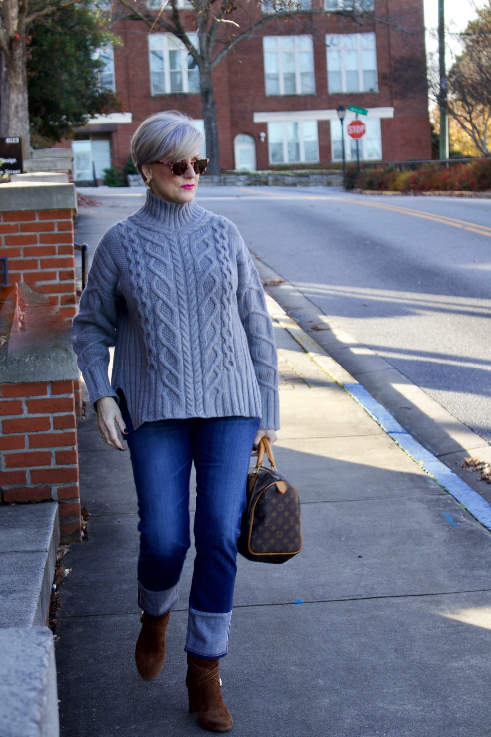 warm and cozy sweater. beth from Style at a Certain Age wears suede booties, cuffed blue jeans, and cable knit sweater