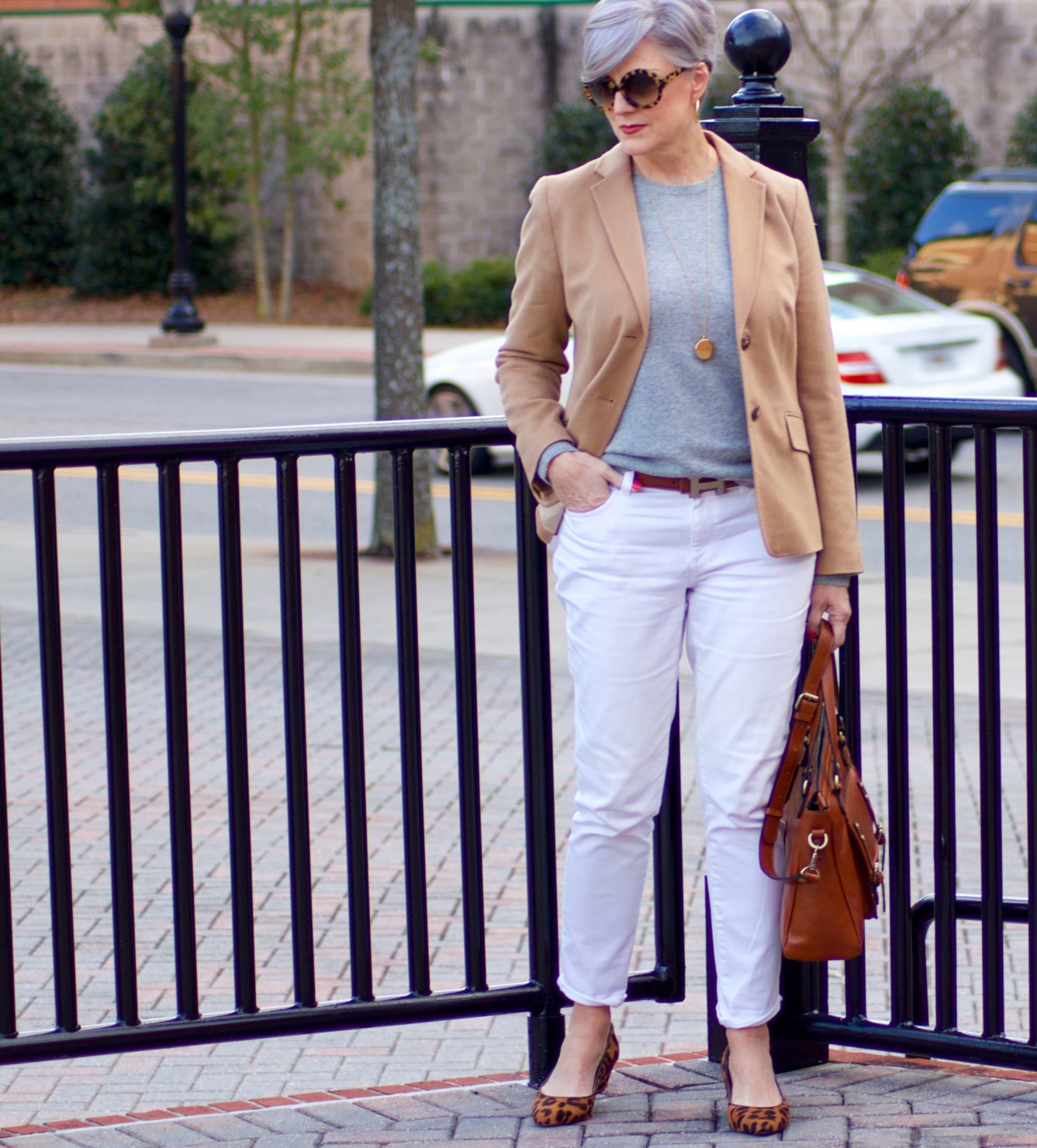 beth from Style at a Certain Age wears a camel blazer, grey cashmere crewneck, white denim, and leopard shoes