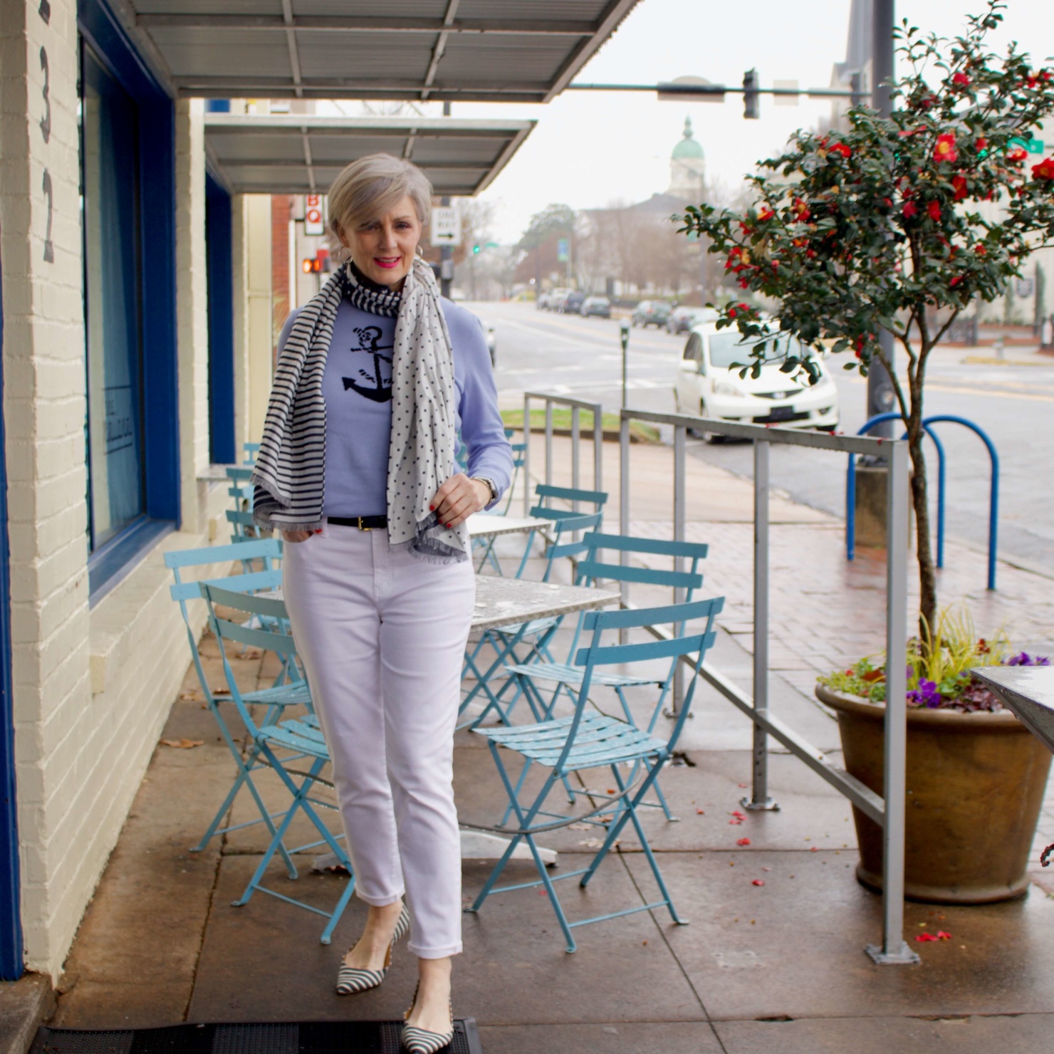 beth from Style at a Certain Age wears a yellow slicker from Talbots, white denim, anchor sweater, polka dot and striped scarf, and striped flats