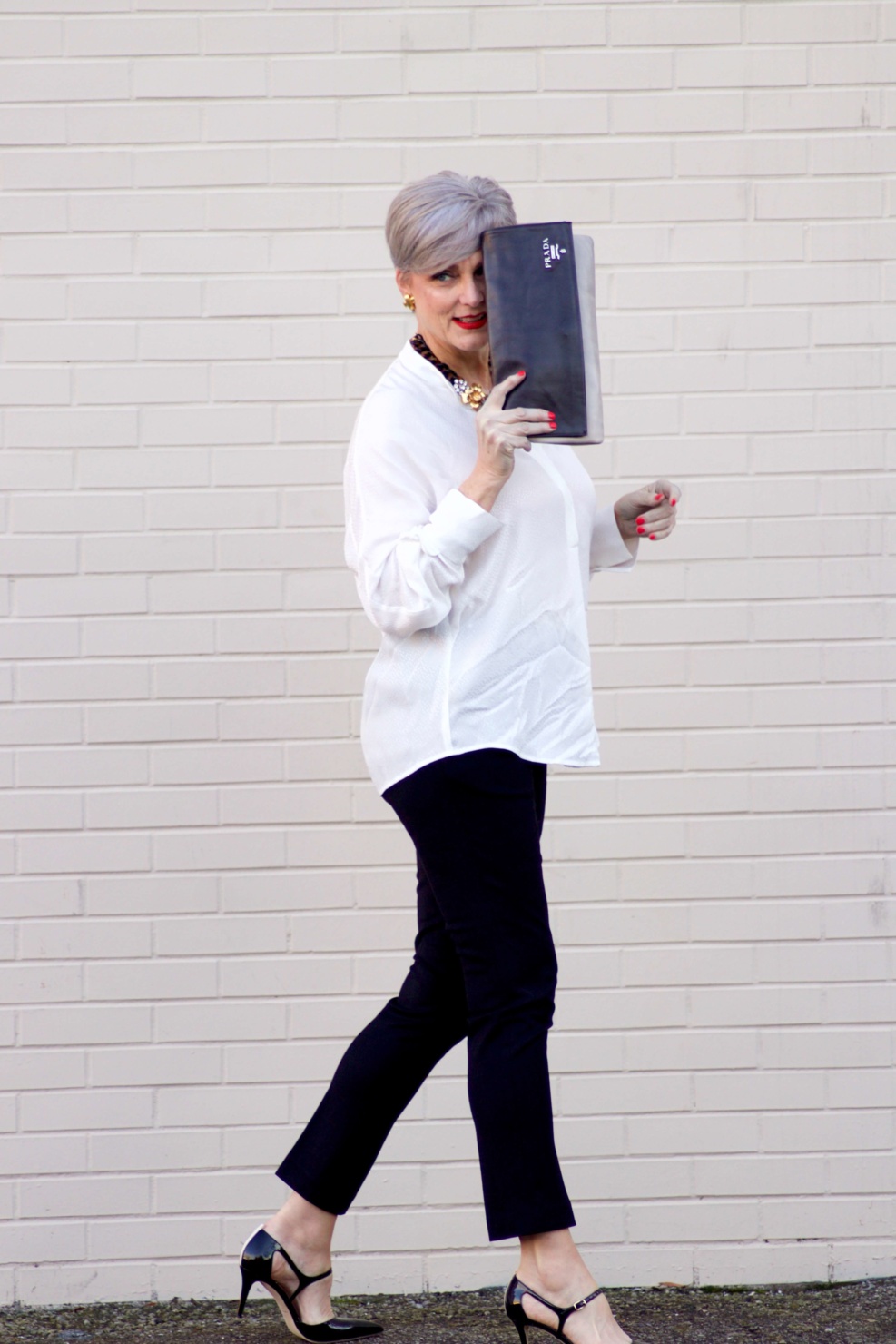 beth from Style at a Certain Age wears an ivory Vince jacquard silk blouse, Everlance slim wool pant, and SJP mary jane patent leather shoes