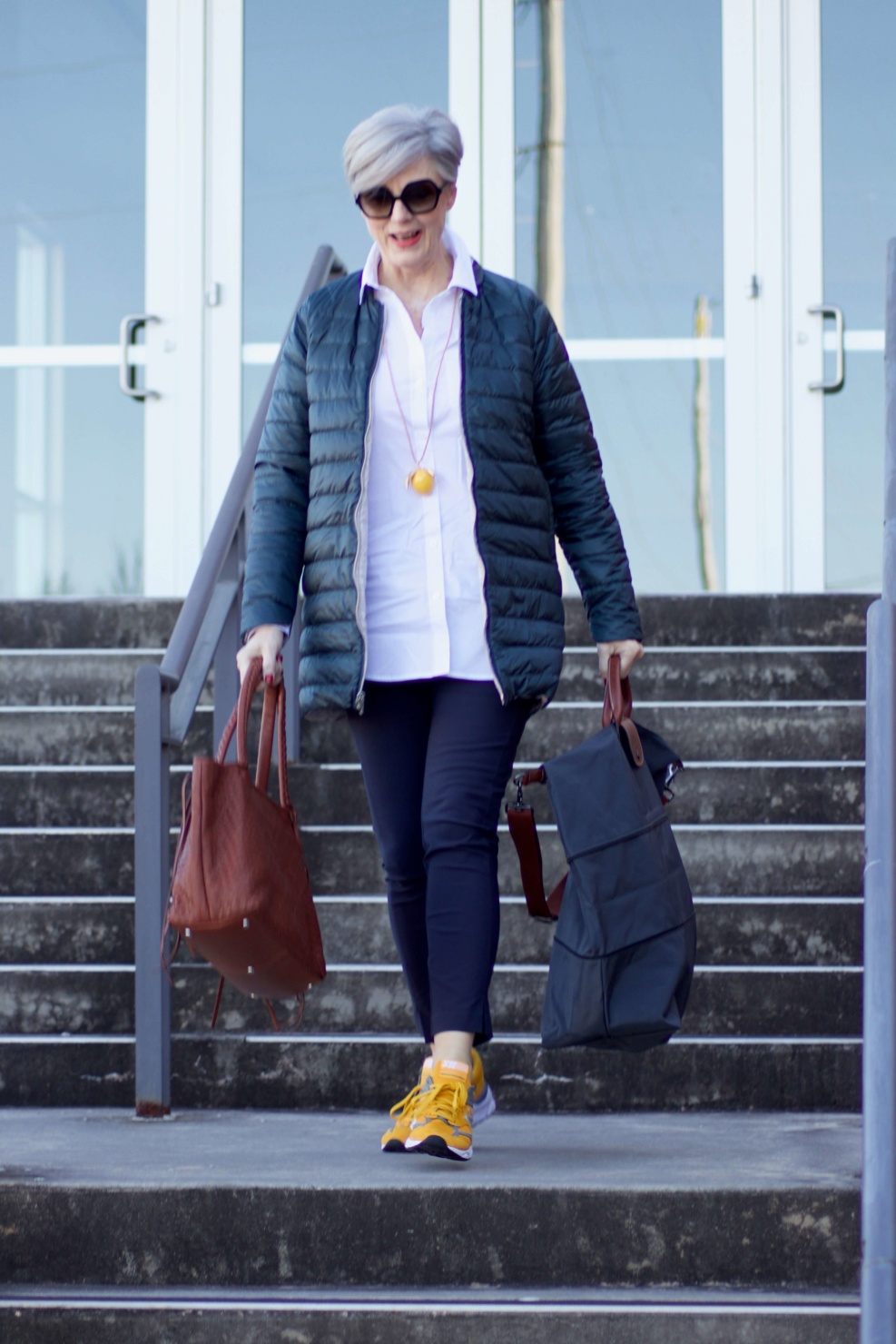 beth from Style at a Certain Age wears Athleta pants, white shirt, puffer jacket, and sneakers