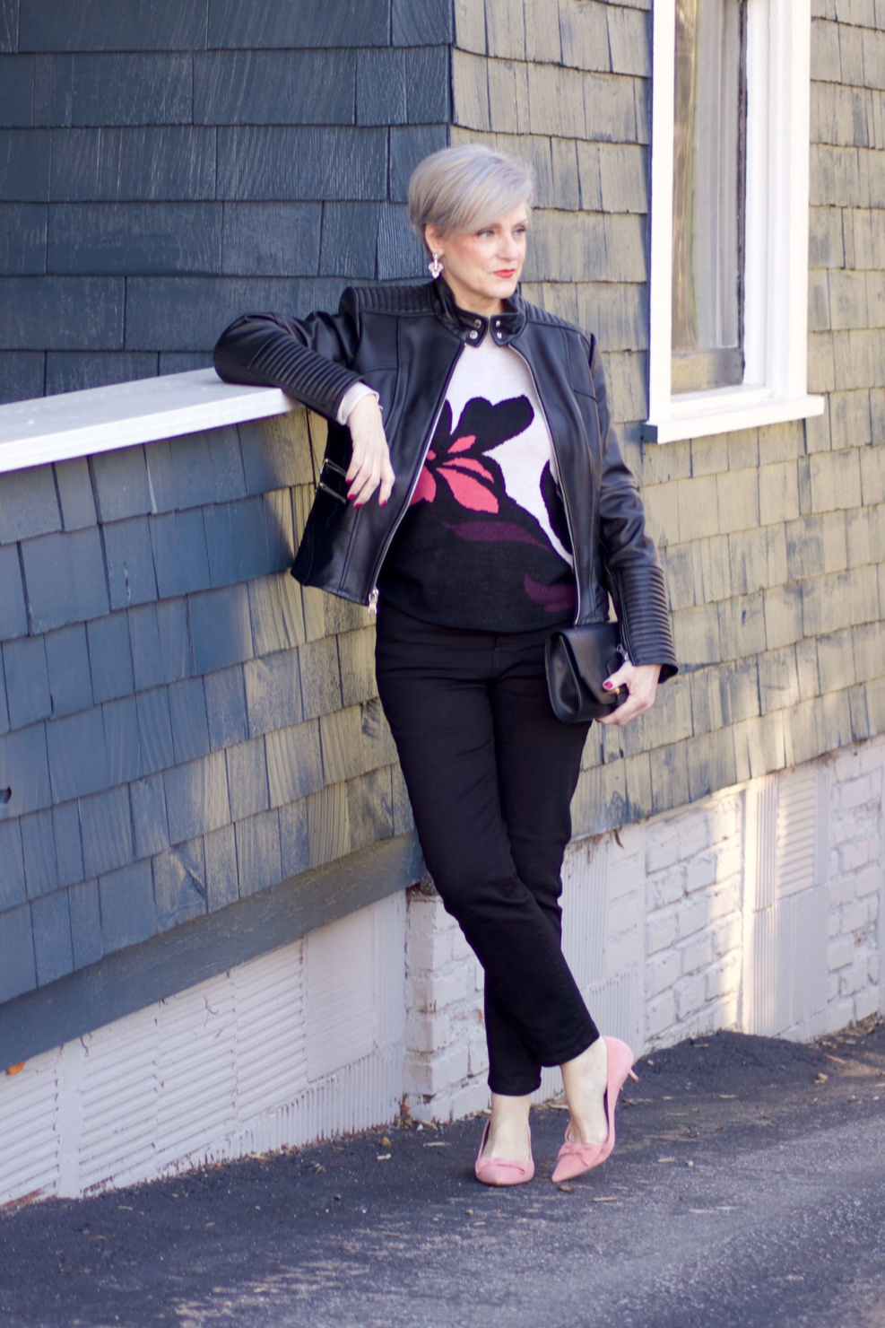 beth from Style at a Certain Age wears a floral jacquard sweater, black skinny jeans, black leather moto jacket and pink suede pumps for date night