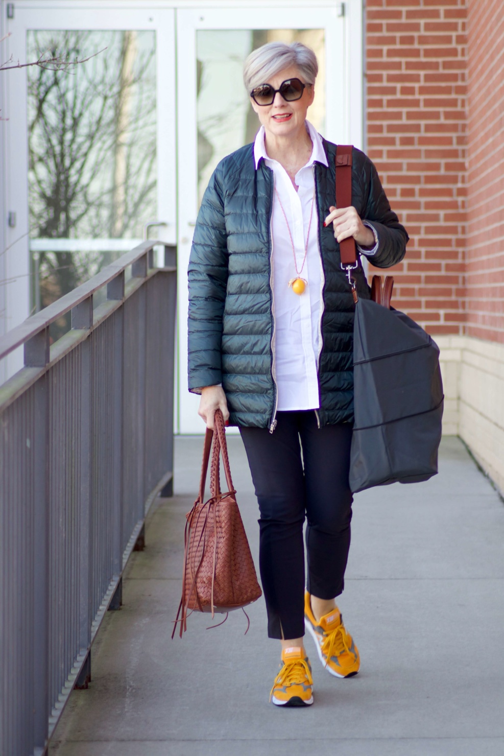 beth from Style at a Certain Age wears Athleta pants, white shirt, puffer jacket, and sneakers