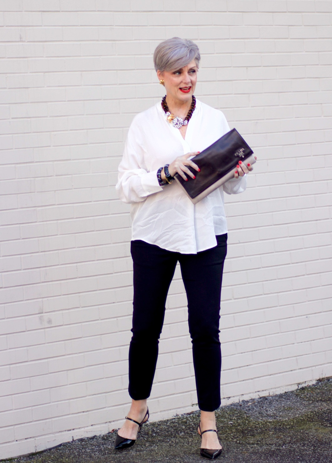 beth from Style at a Certain Age wears an ivory Vince jacquard silk blouse, Everlance slim wool pant, and SJP mary jane patent leather shoes