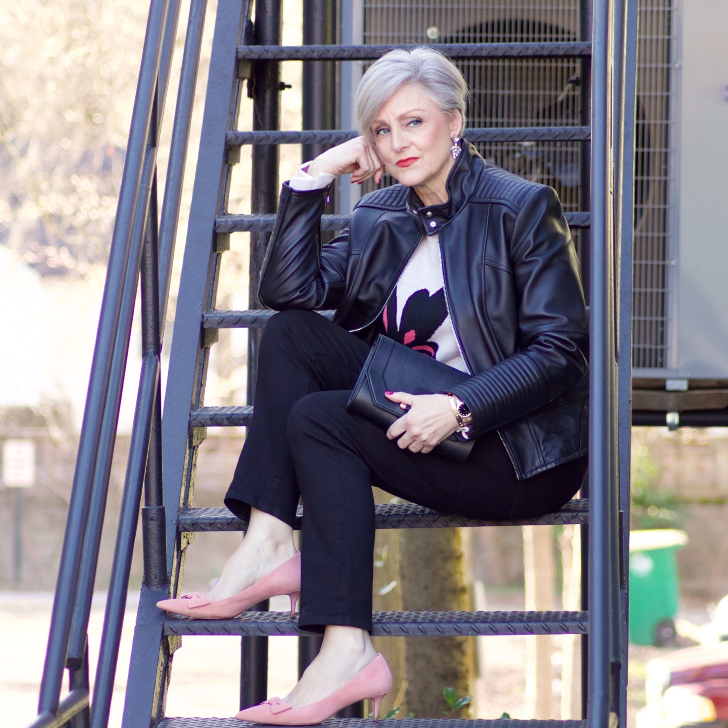 beth from Style at a Certain Age wears a floral jacquard sweater, black skinny jeans, black leather moto jacket and pink suede pumps for date night