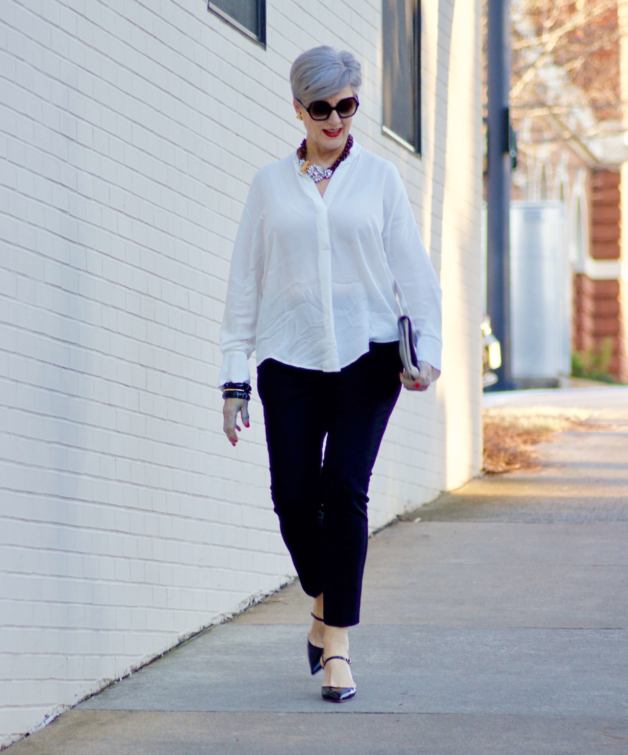 beth from Style at a Certain Age wears an ivory Vince jacquard silk blouse, Everlance slim wool pant, and SJP mary jane patent leather shoes