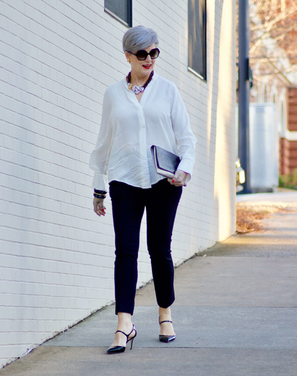 beth from Style at a Certain Age wears an ivory Vince jacquard silk blouse, Everlance slim wool pant, and SJP mary jane patent leather shoes