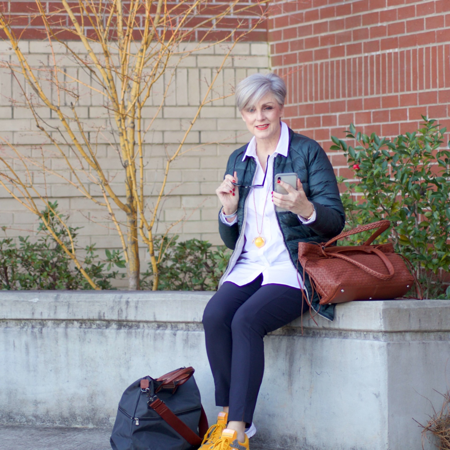 beth from Style at a Certain Age wears Athleta pants, white shirt, puffer jacket, and sneakers