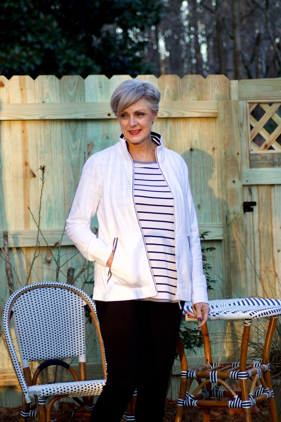 beth from Style at a Certain Age wears a stripe t-shirt, black yoga pants, and white track jacket