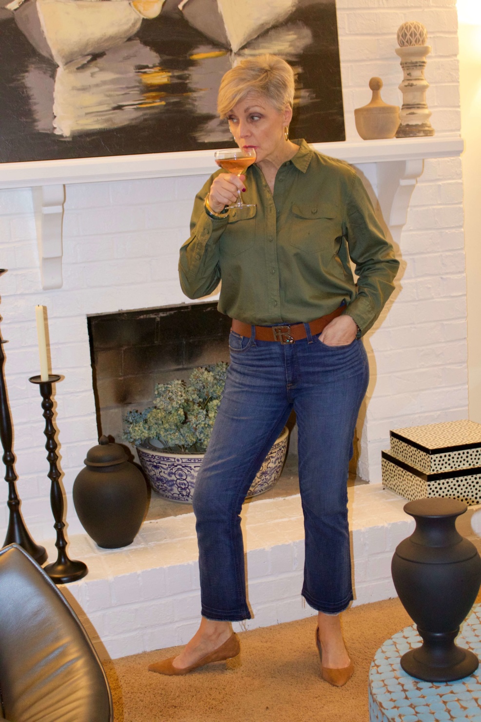 beth from Style at a Certain Age wears a green utility shirt, frayed denim, and suede block heel shoes