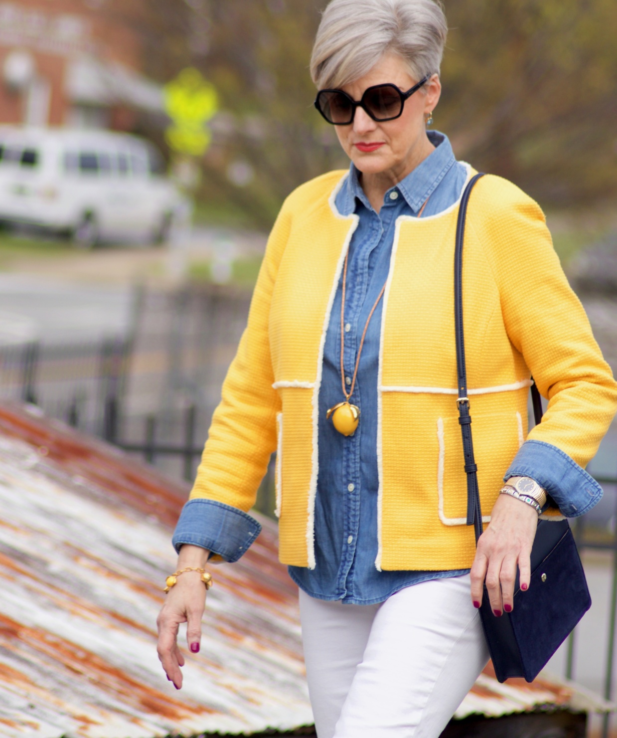 beth from Style at a Certain Age wears a Boden yellow blazer, chambray shirt, white denim and striped shoes