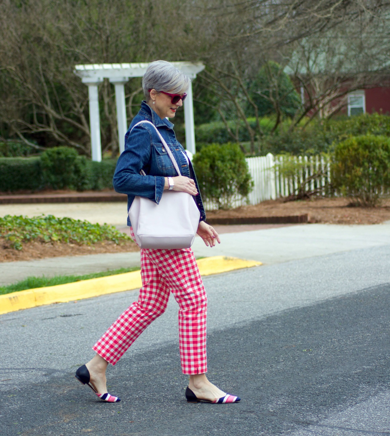 beth from Style at a Certain Age wears pink gingham pants, graphic tee, and denim jacket