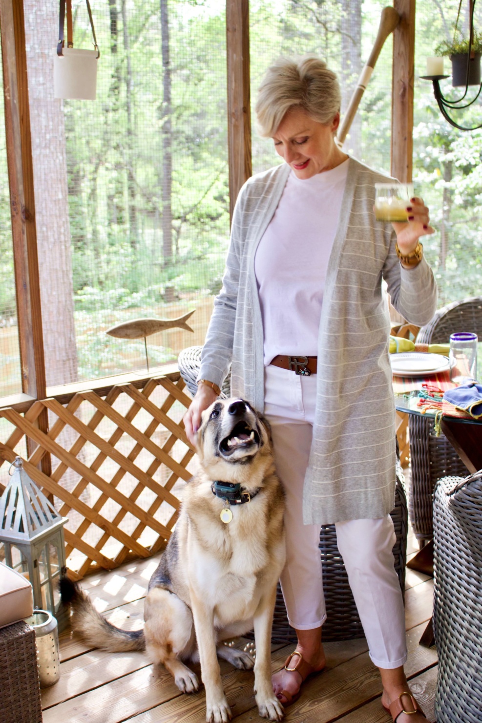 beth from Style at a Certain Age wears white girlfriend chinos, white muscle tee, gray cardigan, and brown sandals