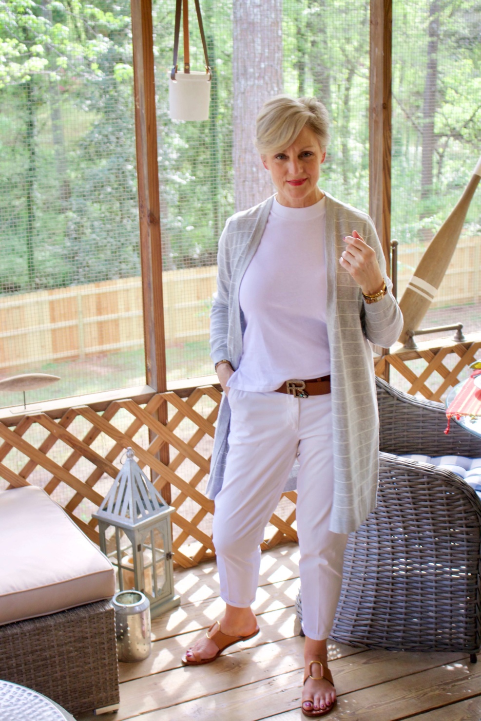 beth from Style at a Certain Age wears white girlfriend chinos, white muscle tee, gray cardigan, and brown sandals