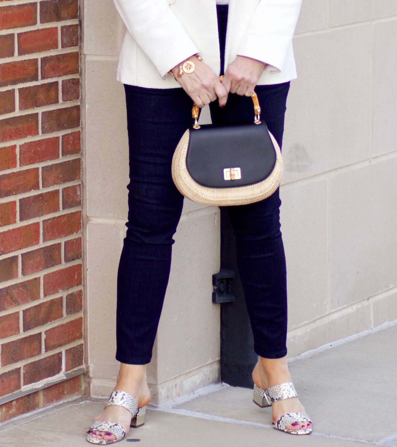 beth from Style at a Certain Age wears a textured ivory blazer, ivory scalloped shell, dark rinse skinny jeans, snakeskin sandals and wicker handbag