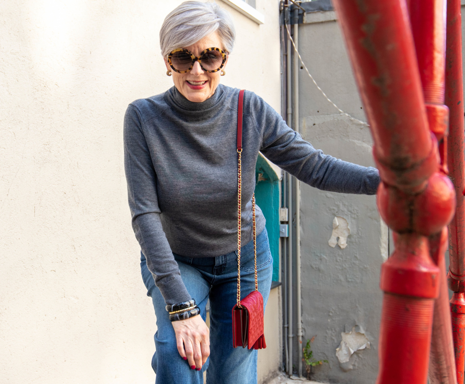 gray turtleneck, red handbag