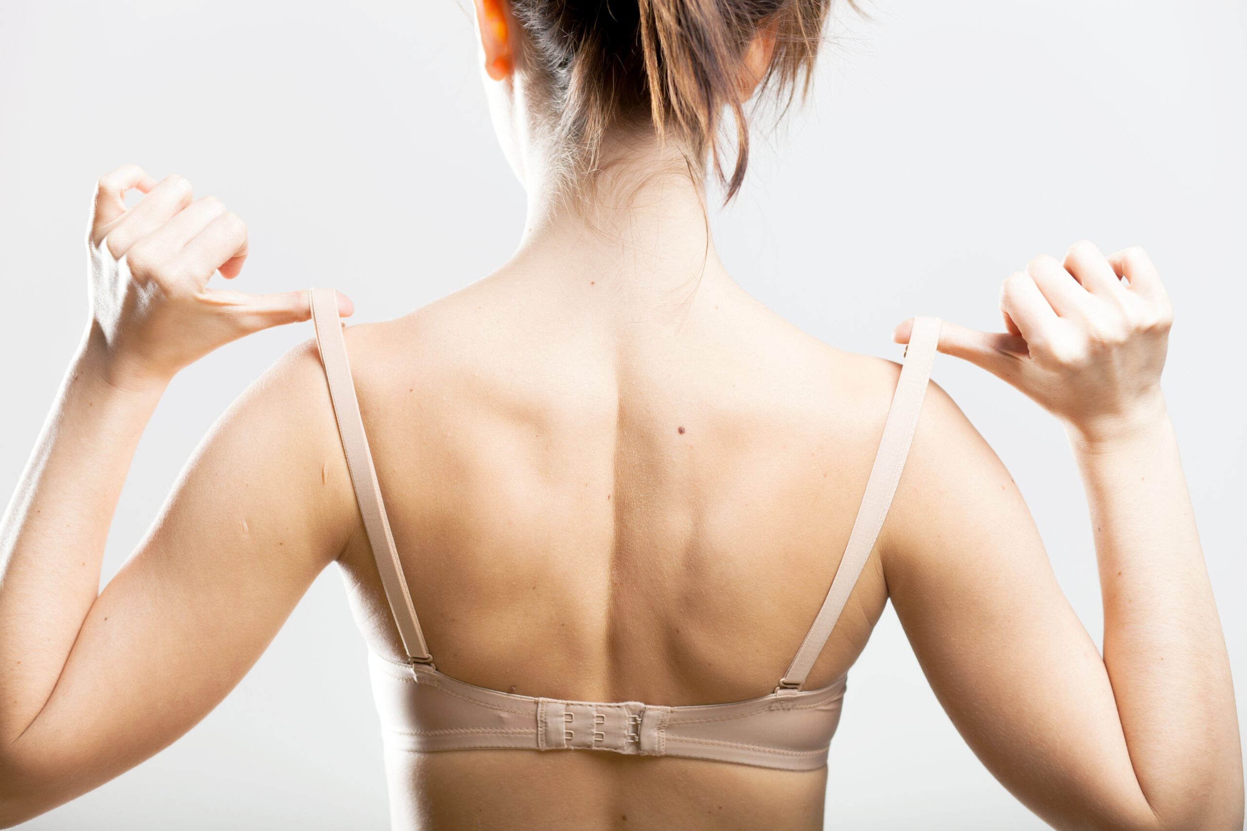 Woman,Holding,A,Skin,Colored,Bra,Strap,,Closeup,Back,View